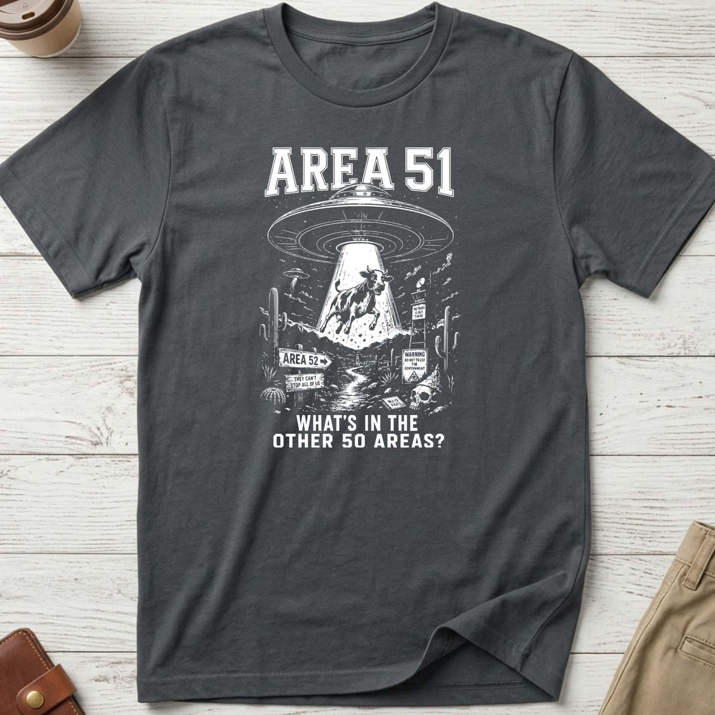 Area 51 graphic t-shirt featuring a flying saucer abducting a cow with the funny quote "What's In The Other 50 Areas?" on a grey unisex tee.