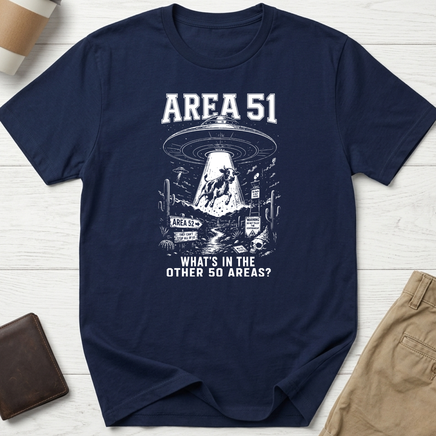 Area 51 graphic t-shirt featuring a flying saucer abducting a cow with the funny quote "What's In The Other 50 Areas?" on a navy unisex tee.