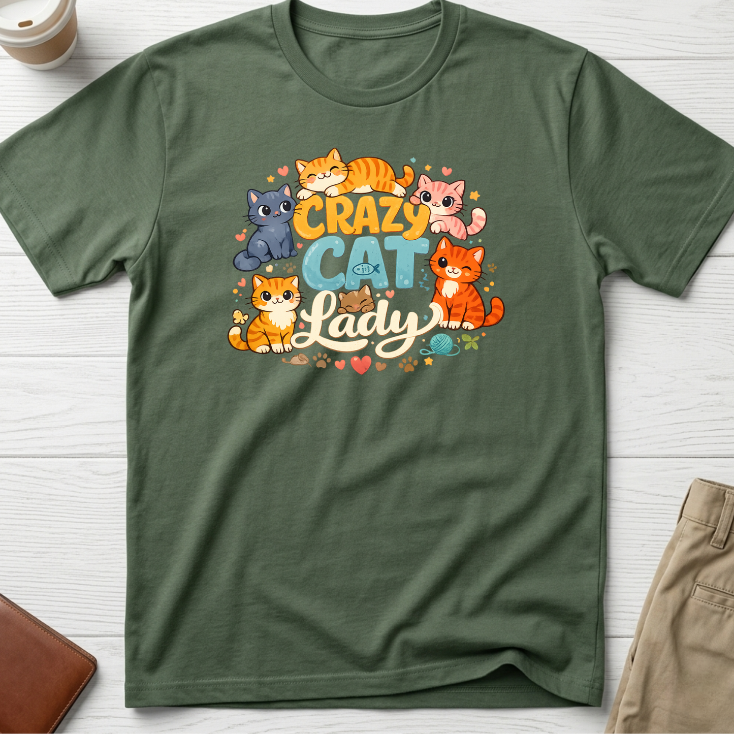 Crazy Cat Lady graphic t-shirt featuring colourful cartoon kittens and playful typography on a green unisex tee.
