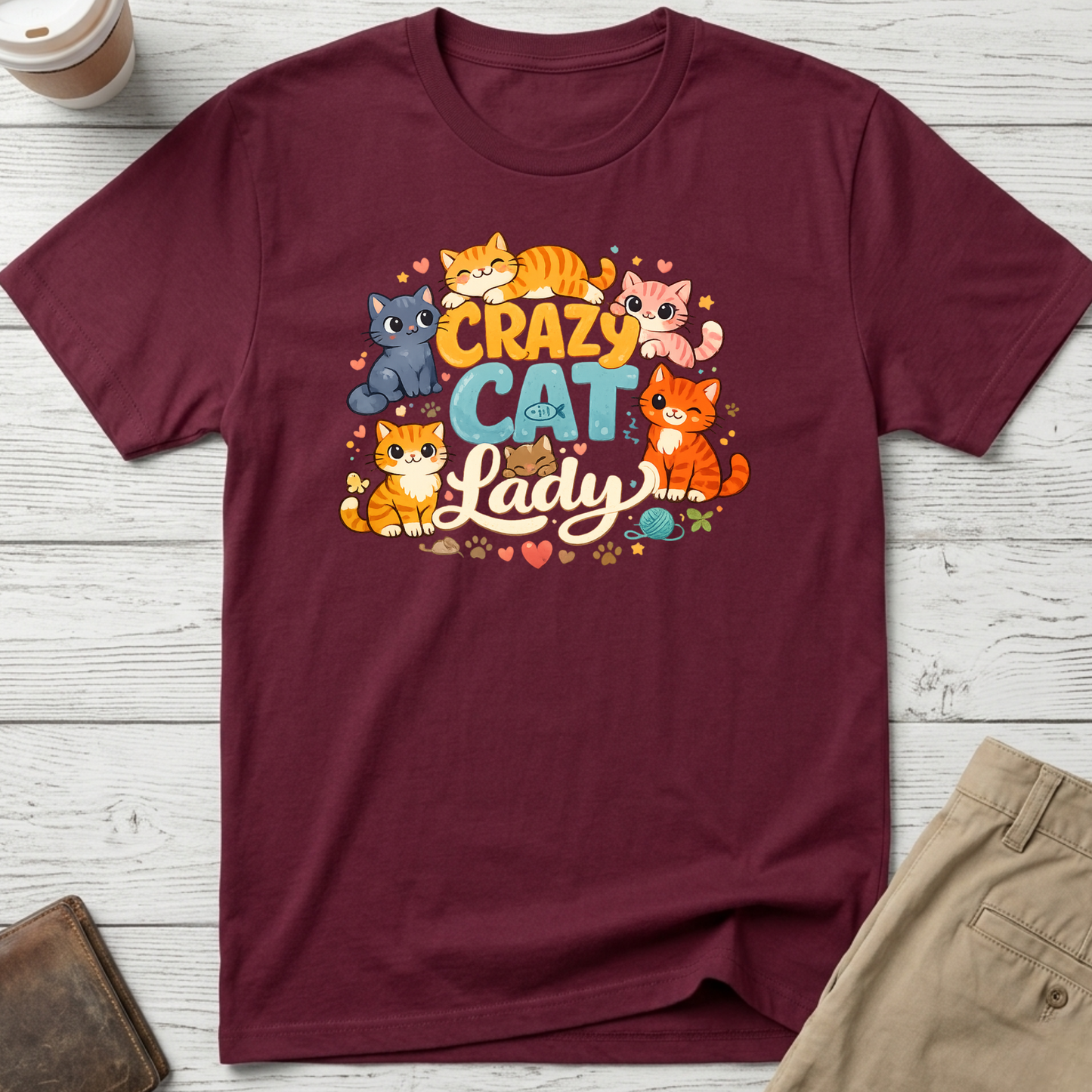 Crazy Cat Lady graphic t-shirt featuring colourful cartoon kittens and playful typography on a maroon unisex tee.