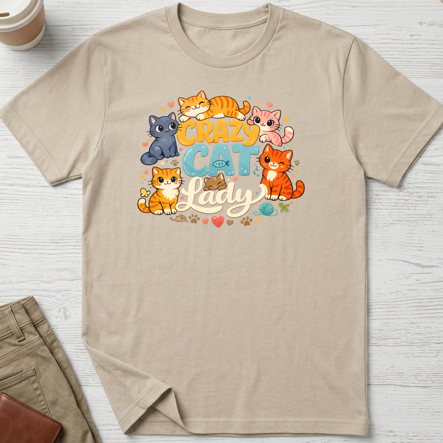 Crazy Cat Lady graphic t-shirt featuring colourful cartoon kittens and playful typography on a sand unisex tee.