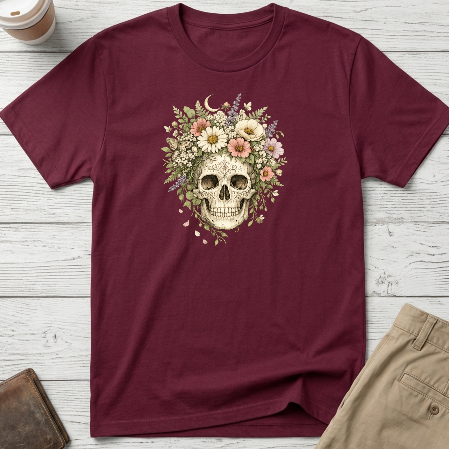Floral Skull graphic t-shirt featuring a vintage skull surrounded by blooming wildflowers and botanical elements on a maroon unisex tee.