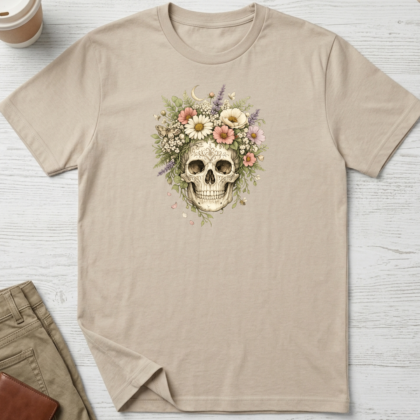 Floral Skull graphic t-shirt featuring a vintage skull surrounded by blooming wildflowers and botanical elements on a sand unisex tee.