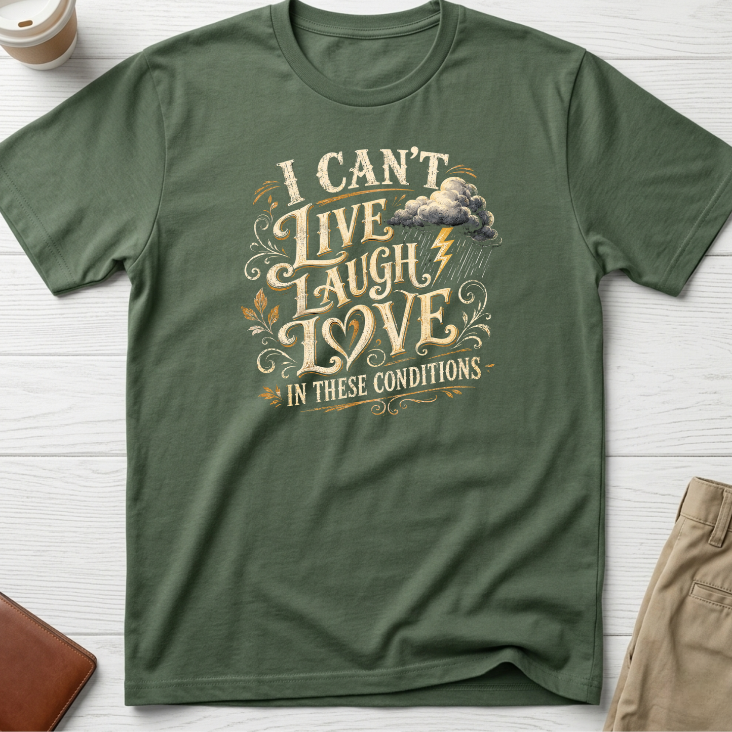 I Can’t Live Laugh Love In These Conditions funny sarcastic t-shirt featuring vintage cream lettering with storm cloud and lightning graphic on a green unisex tee.