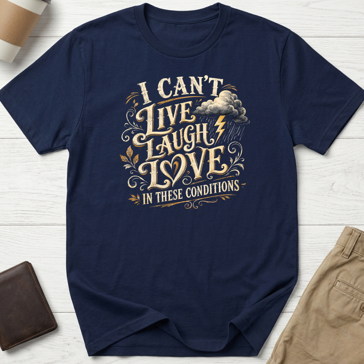 I Can’t Live Laugh Love In These Conditions funny sarcastic t-shirt featuring vintage cream lettering with storm cloud and lightning graphic on a navy unisex tee.