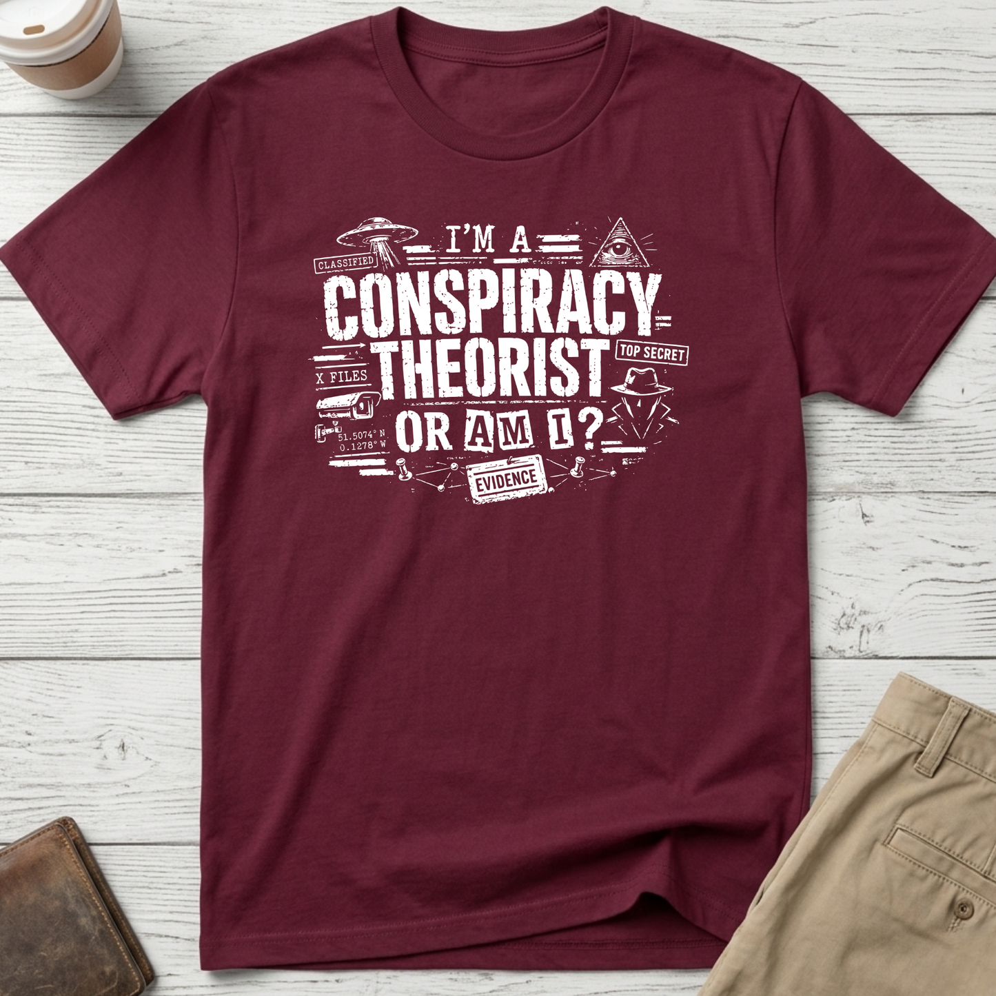 I'm A Conspiracy Theorist Or Am I graphic t-shirt featuring UFOs, classified files, secret agent artwork and distressed typography on a maroon unisex tee.