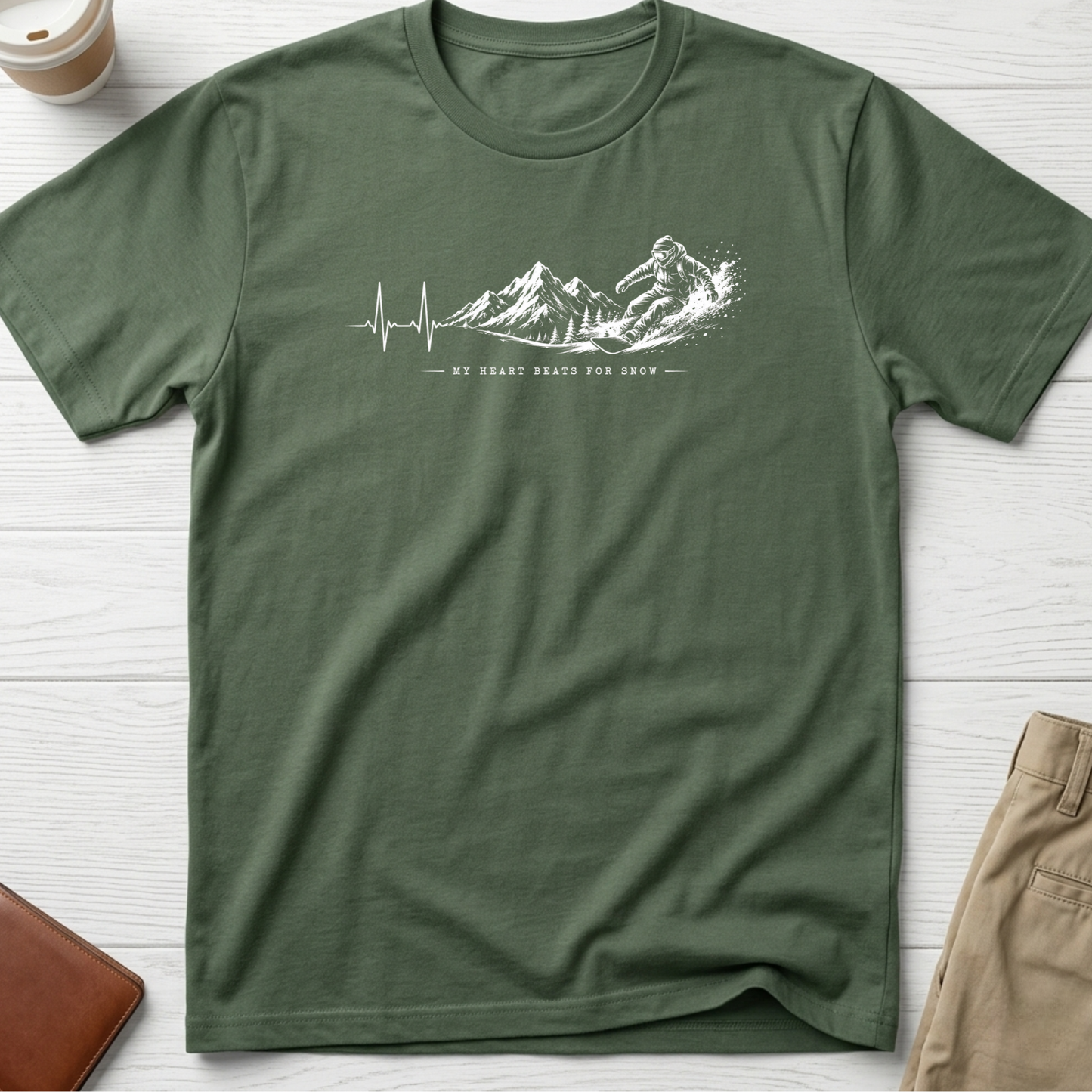 My Heart Beats for Snow graphic t-shirt featuring an ECG heartbeat transforming into mountain peaks with a snowboarder on a green unisex tee.