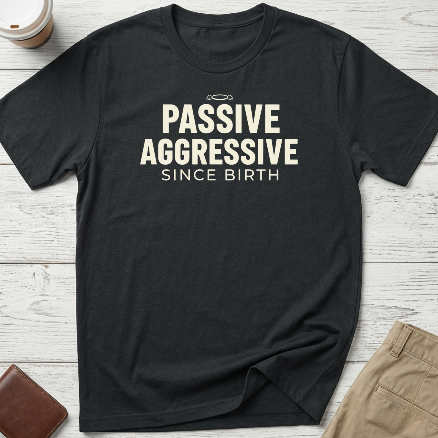 Passive Aggressive Since Birth funny sarcastic t-shirt featuring bold cream text and small halo graphic on a black unisex tee.