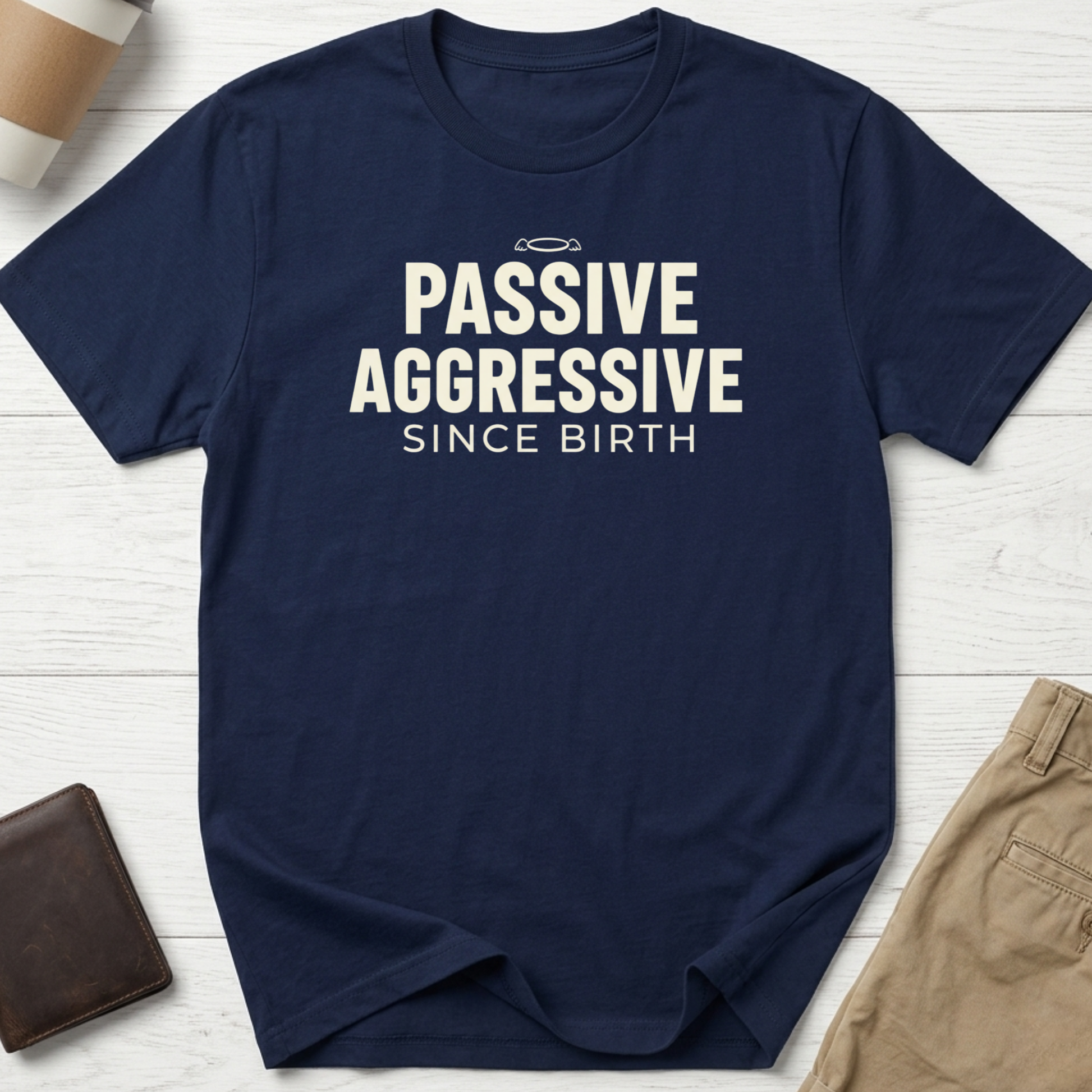 Passive Aggressive Since Birth funny sarcastic t-shirt featuring bold cream text and small halo graphic on a navy blue unisex tee.