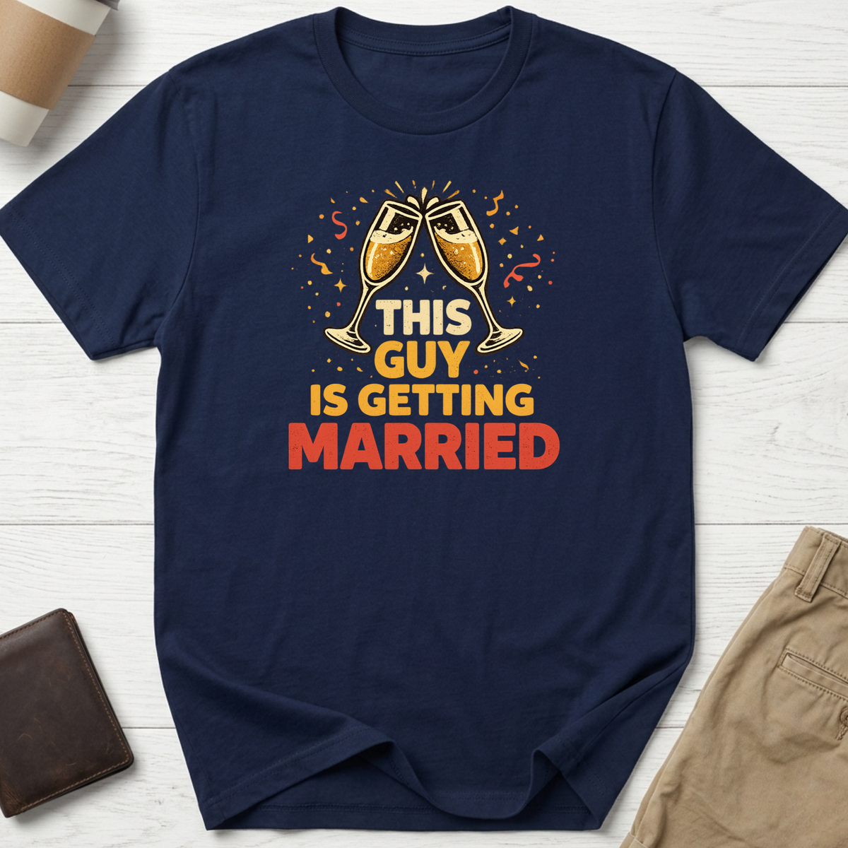This Guy Is Getting Married graphic t-shirt featuring champagne glasses and bold celebration typography on a navy unisex tee.