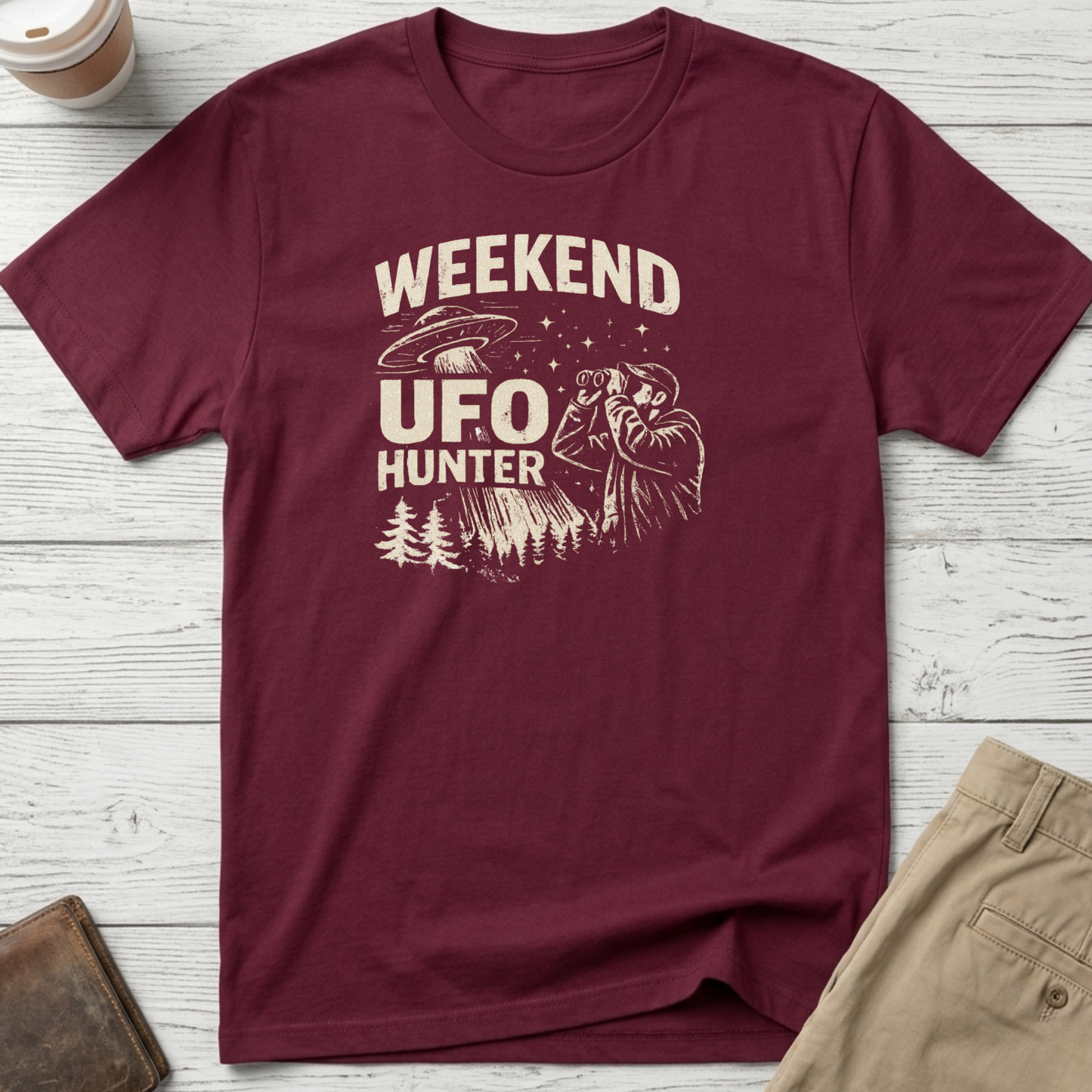 Weekend UFO Hunter funny graphic t-shirt featuring vintage flying saucer artwork and alien hunter illustration on maroon unisex tee.
