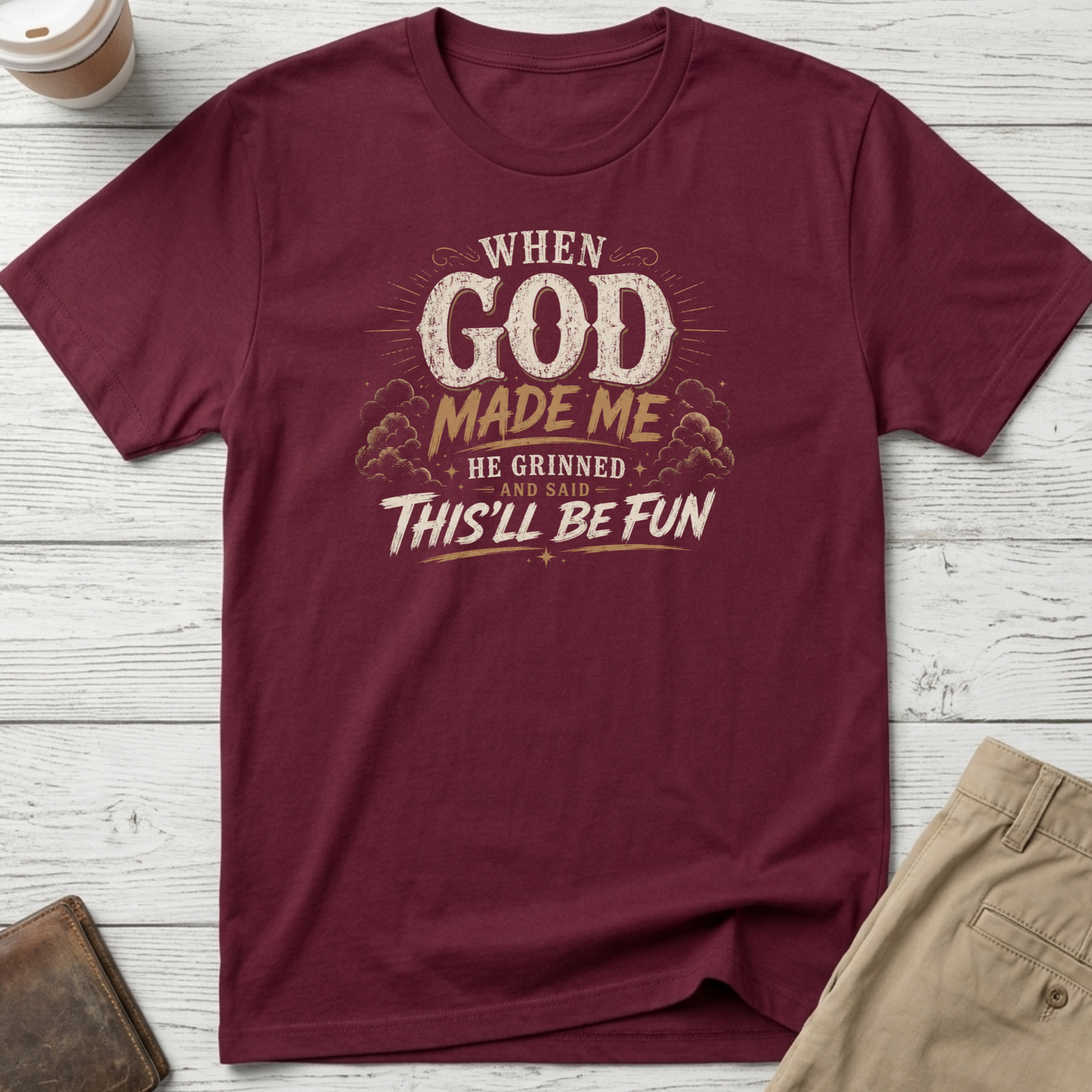 When God Made Me He Grinned And Said This'll Be Fun graphic t-shirt featuring distressed vintage typography on a maroon unisex tee.